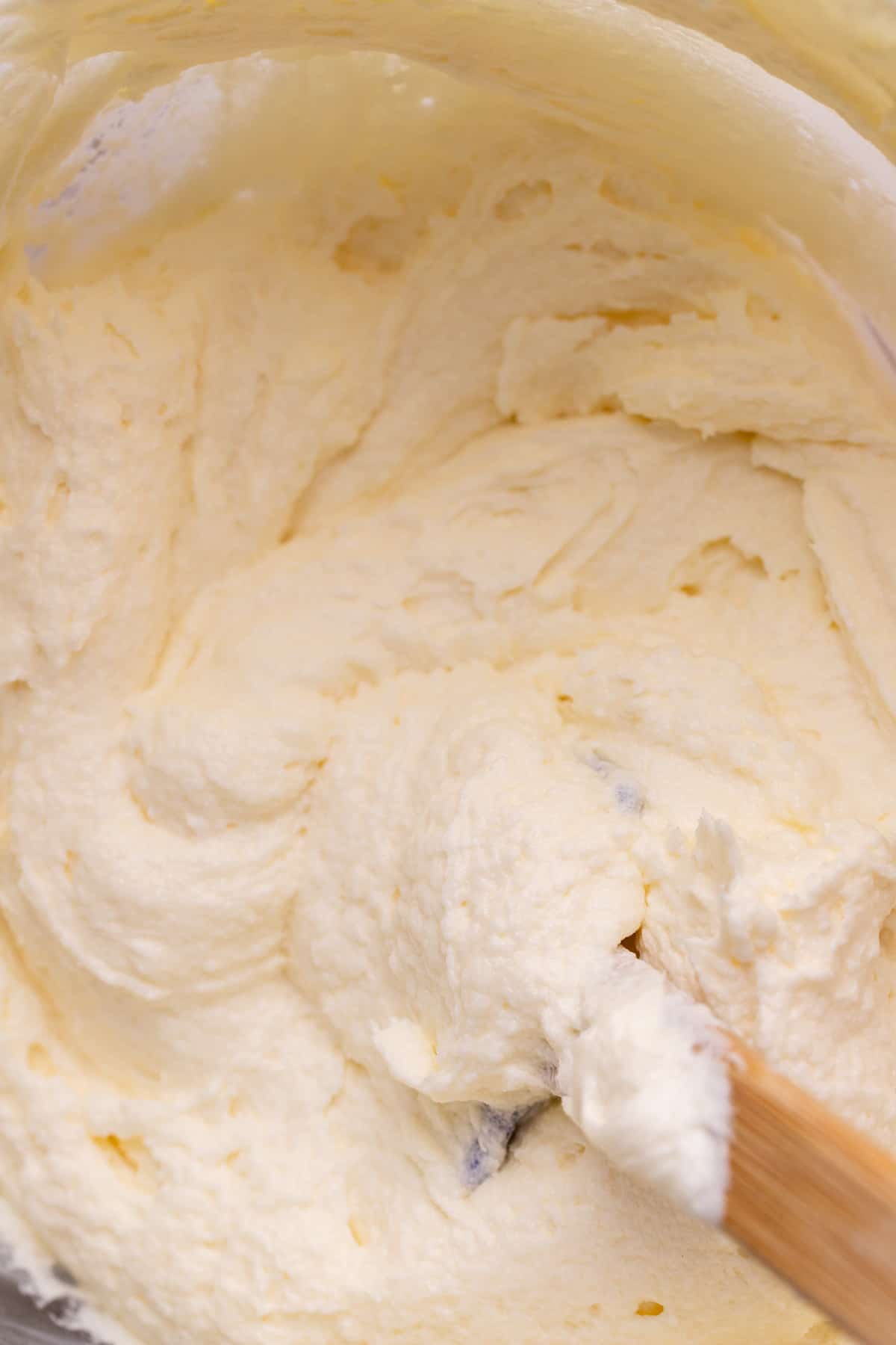 Cream cheese frosting in a glass bowl.