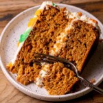 One slice of the best carrot cake with a fork inserted.