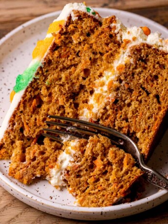 One slice of the best carrot cake with a fork inserted.