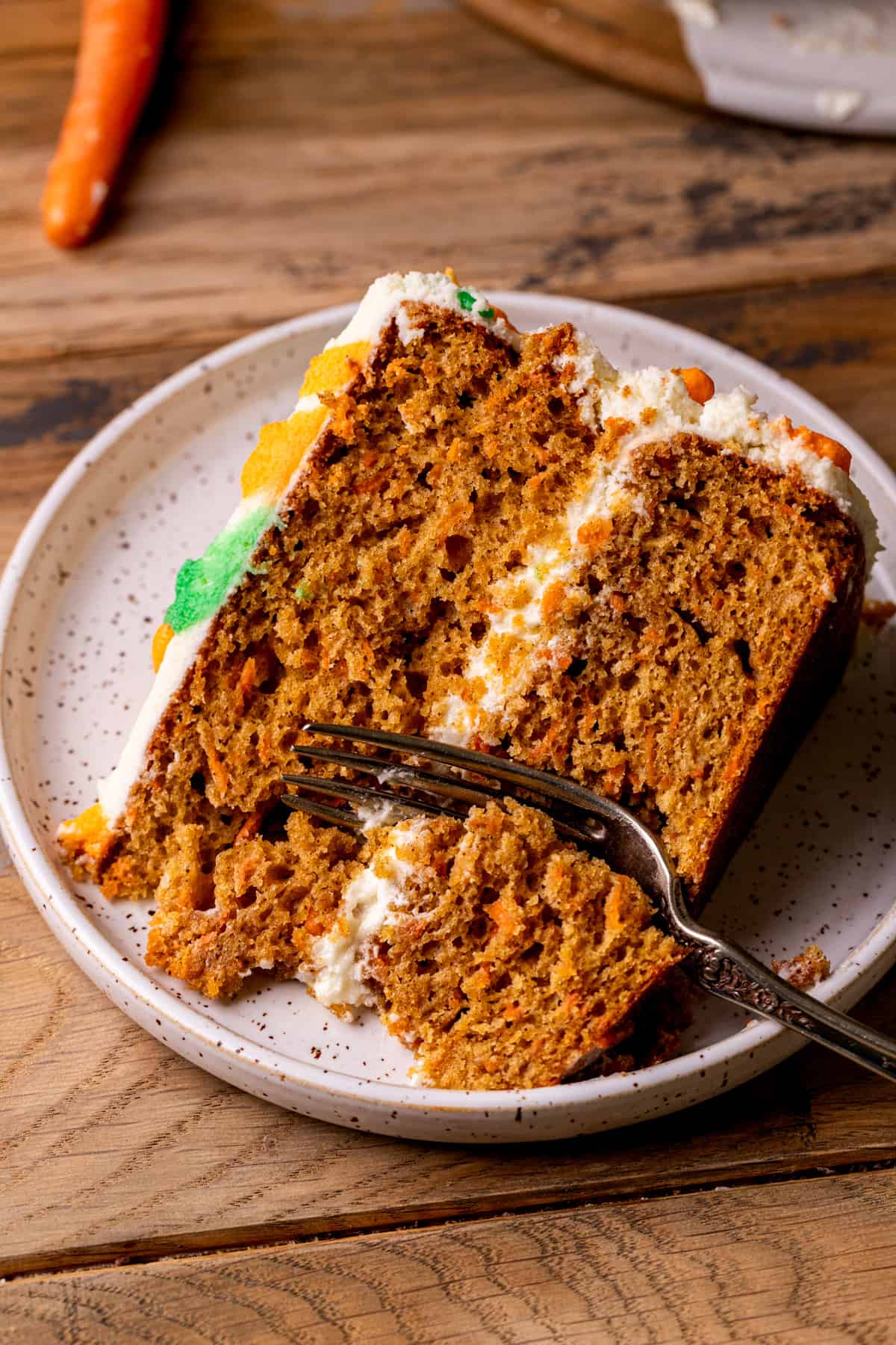 One slice of the best carrot cake with a fork inserted.