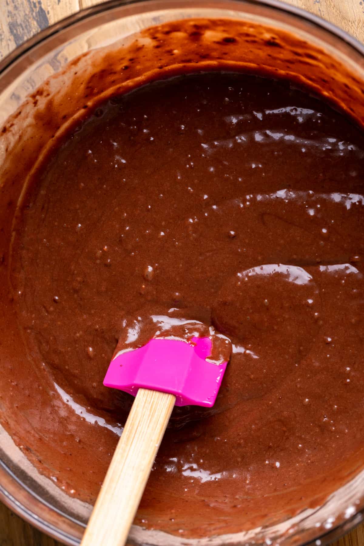Chocolate cake batter in a glass bowl.