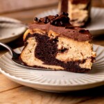 Piece of chocolate peanut butter cheesecake on a plate.