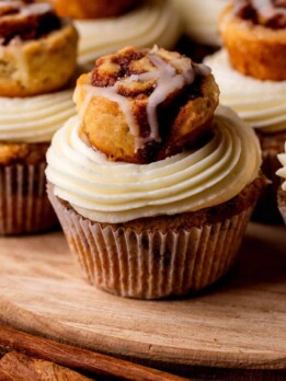 Cinnamon roll cupcakes on a wood board.