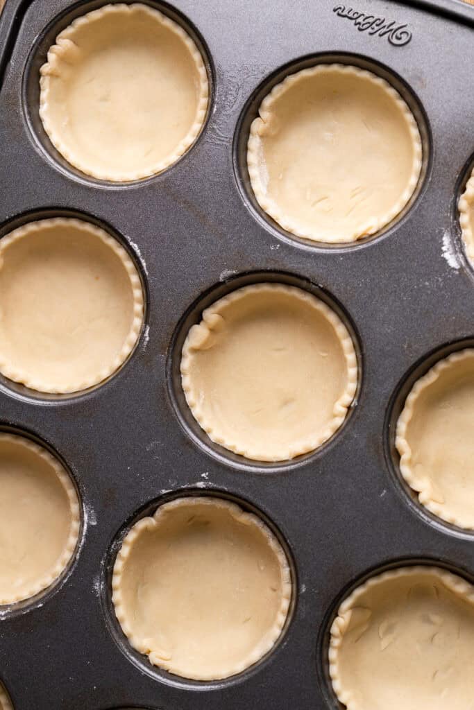 Pie dough in a muffin pan.