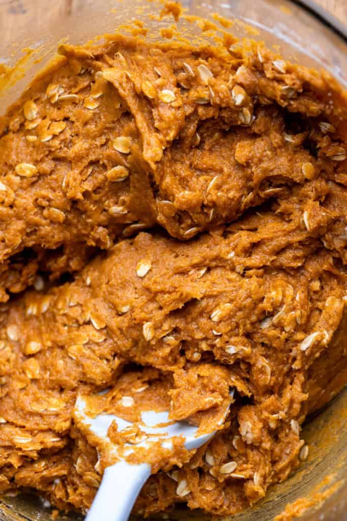 Pumpkin oatmeal cookie dough in a glass bowl.