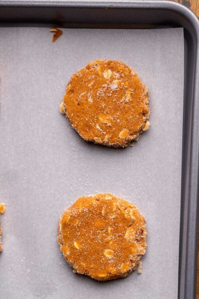 Pumpkin cookie dough balls on a cookie sheet.