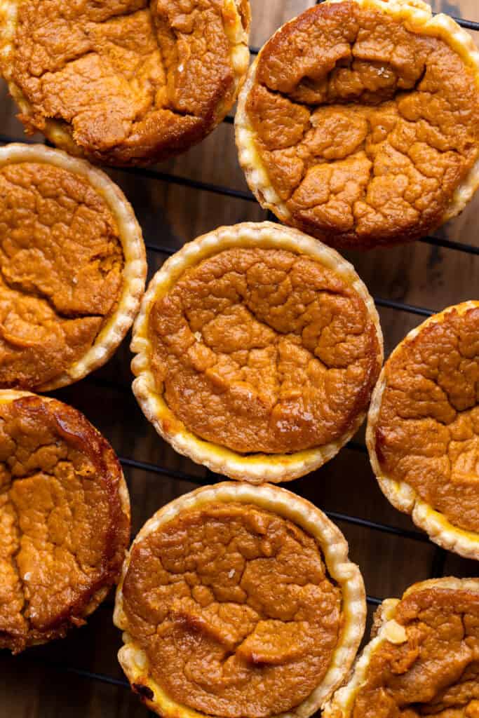 Baked pumpkin pie on a cooling rack.