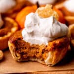 Bite missing from a mini pumpkin pie.