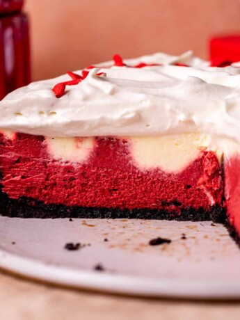 Side view of red velvet cheesecake on a platter.