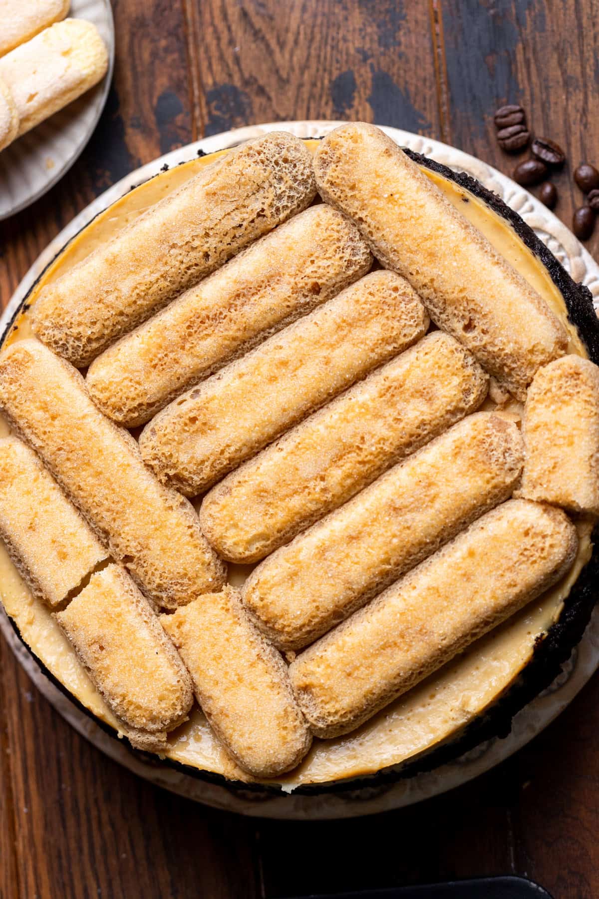 Espresso soaked ladyfingers on top of cheesecake.