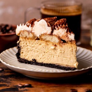 One slice of tiramisu cheesecake on a plate.