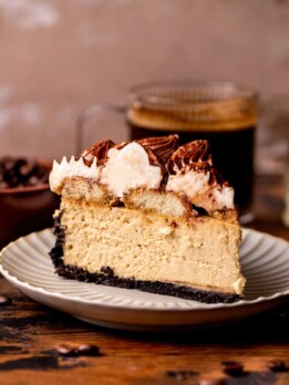 One slice of tiramisu cheesecake on a plate.