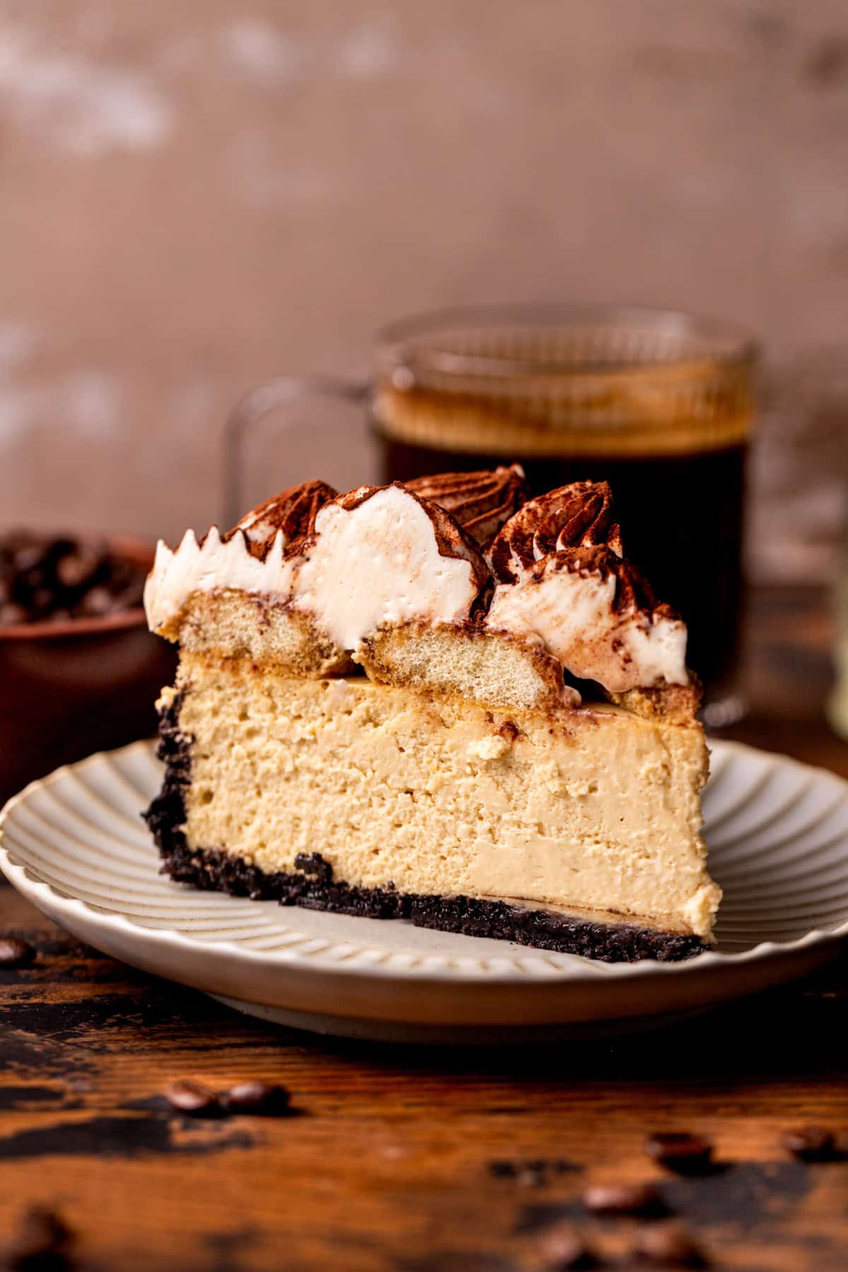 One slice of tiramisu cheesecake on a plate.