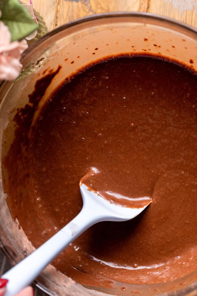 Chocolate cake batter in a glass bowl.
