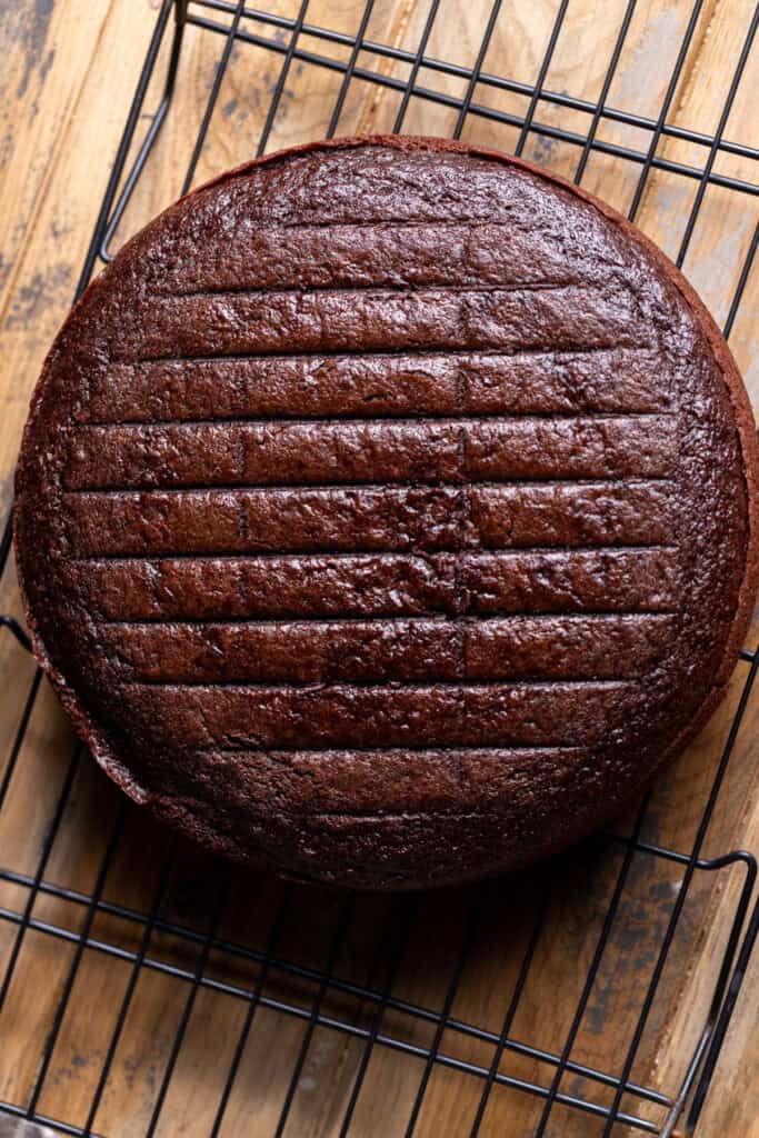 Chocolate cake layer on a wire rack.