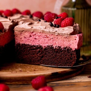 Chocolate raspberry mousse cake on a board.