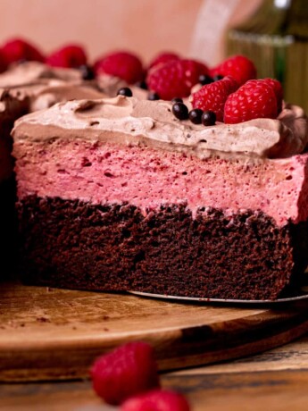 Chocolate raspberry mousse cake on a board.