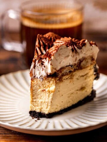 Bite missing from slice of tiramisu cheesecake.