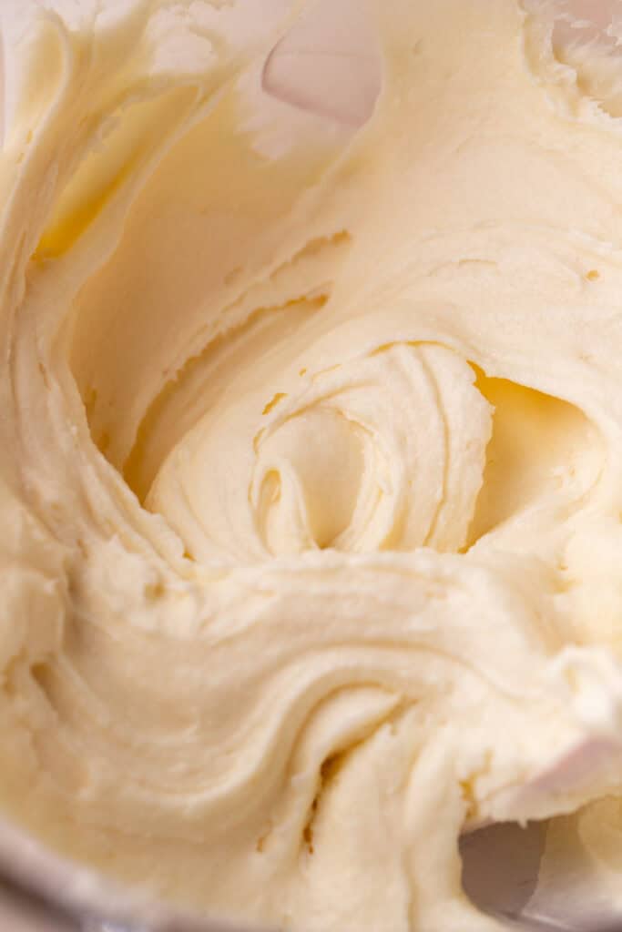 Cream cheese frosting in a glass bowl.