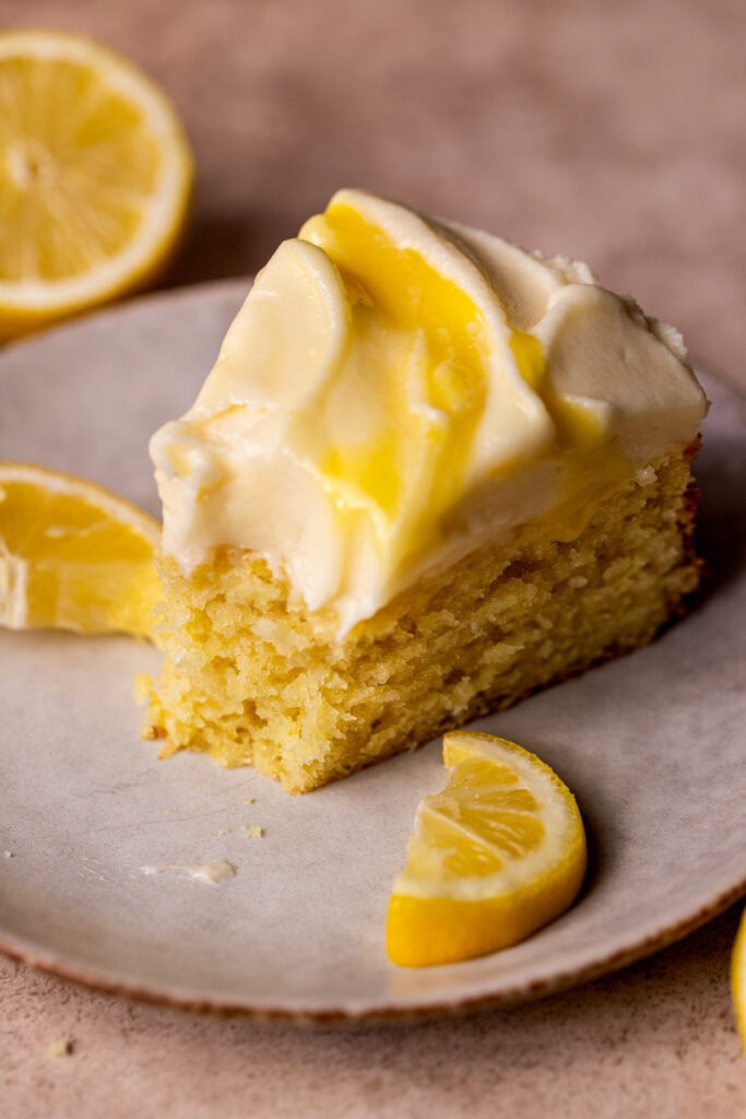 One slice of lemon curd cake on a plate.