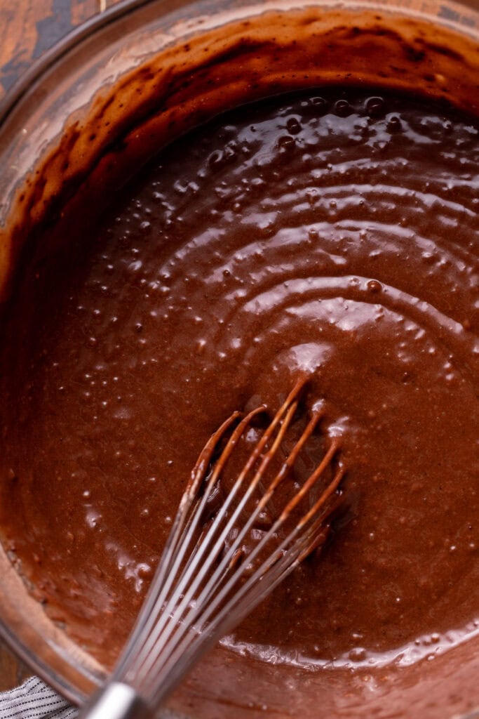 Chocolate cake batter in a glass bowl.