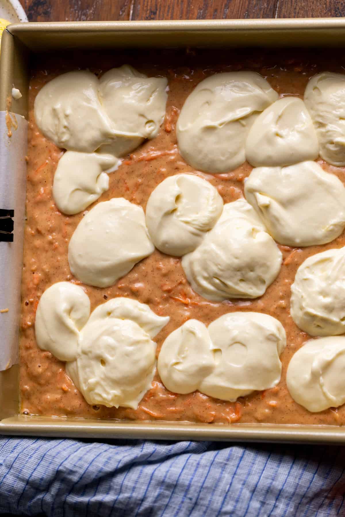 Cream cheese dolloped on top of cake batter.