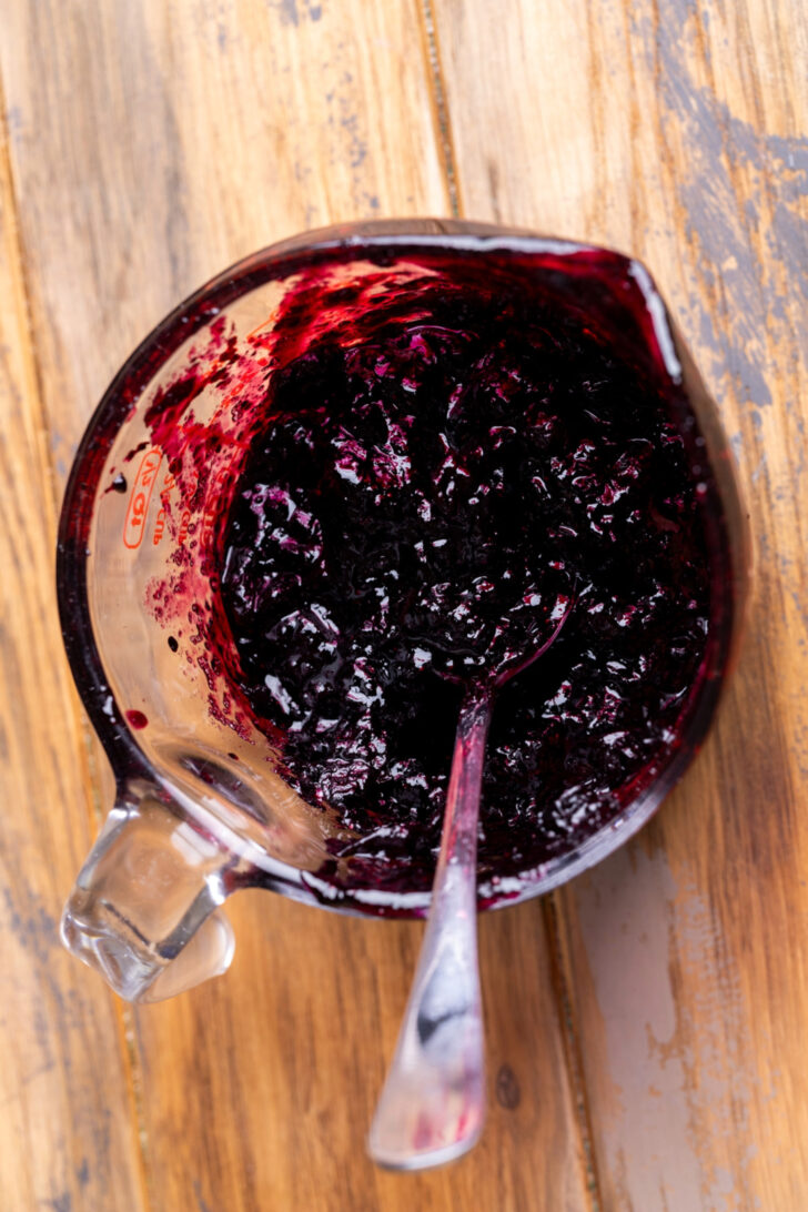 Blueberry jam in a measuring cup.