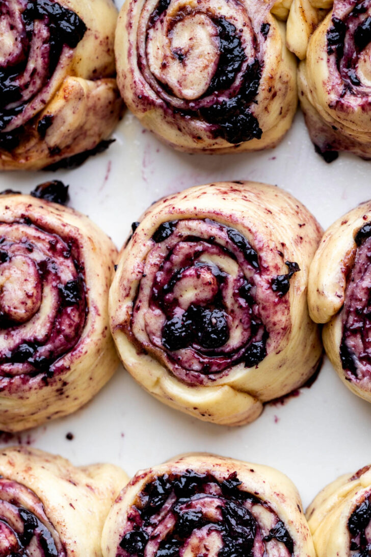 Raw cinnamon rolls in a pan.