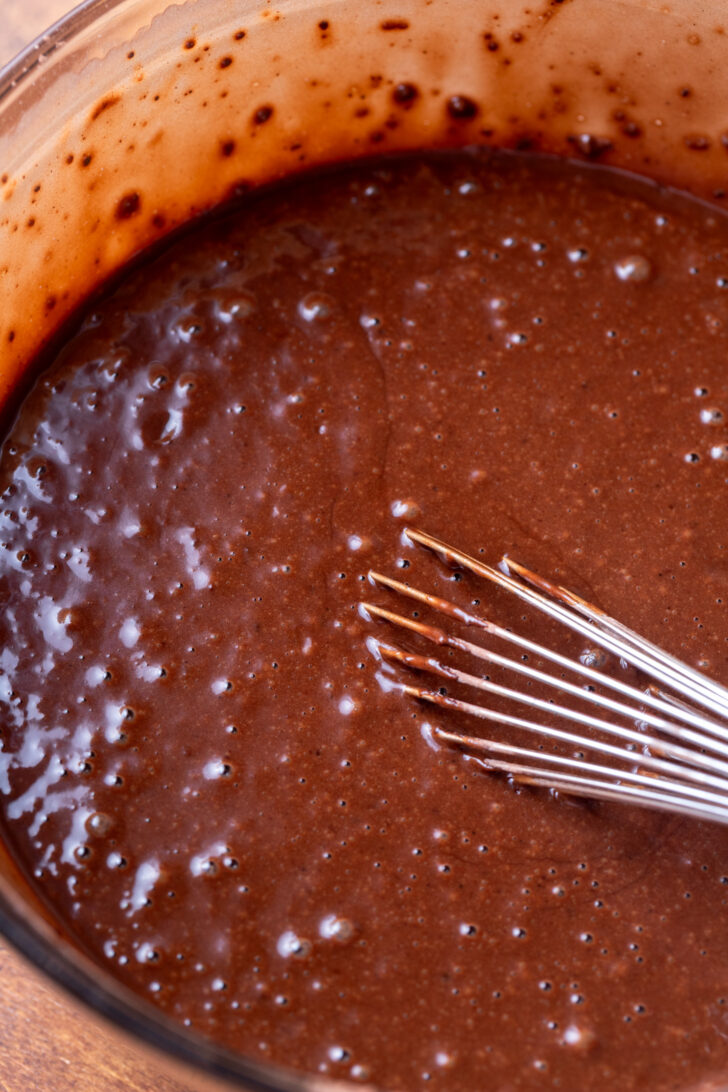 Chocolate cake batter in a glass bowl.