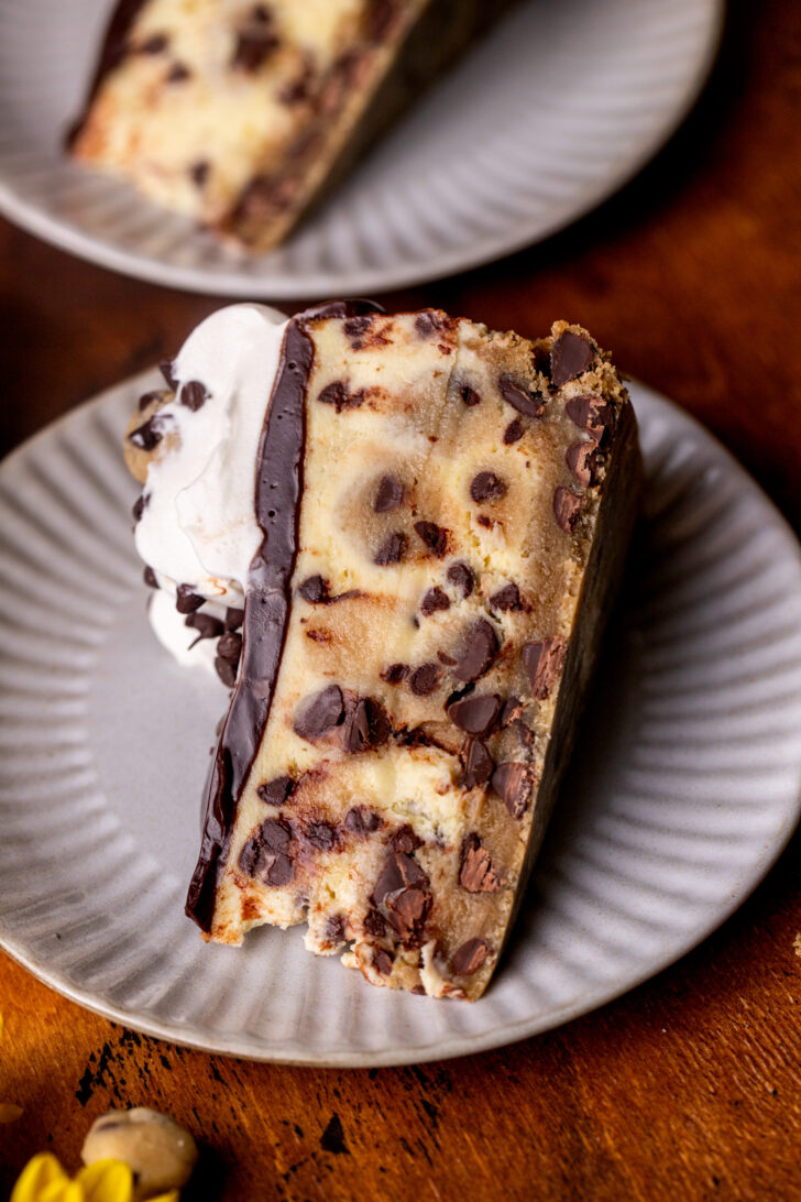 One slice of cheesecake on a plate on its side.