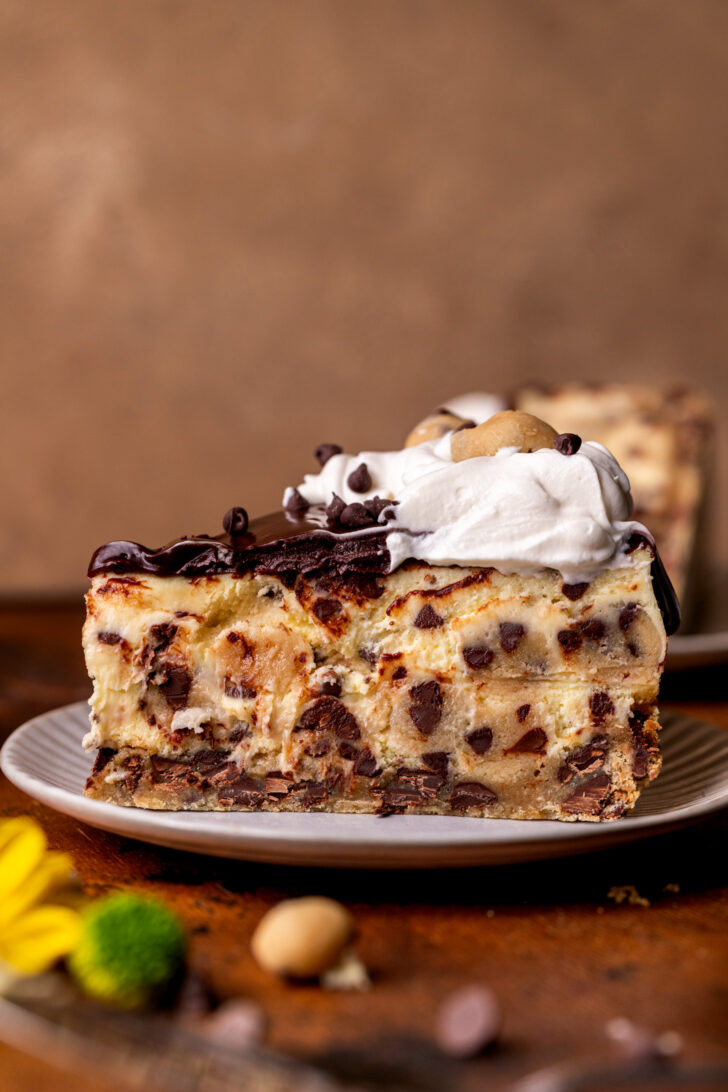 One slice of cookie dough cheesecake on a plate.