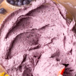 Blueberry frosting in a glass bowl.