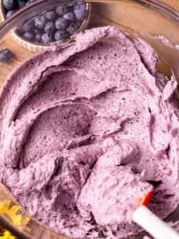 Blueberry frosting in a glass bowl.