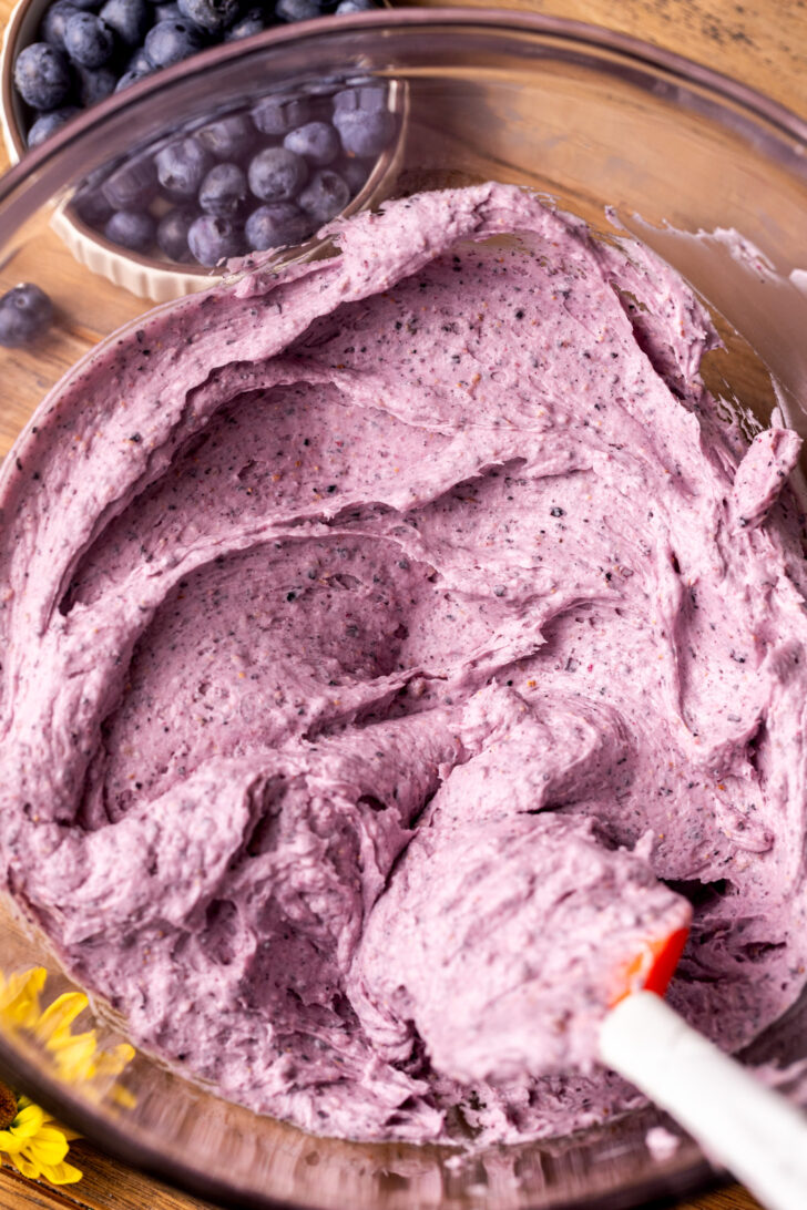 Blueberry frosting in a glass bowl.