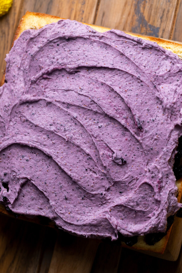 Blueberry frosting on top of cake.