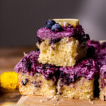 Three lemon blueberry cake slices stacked on top of each other.