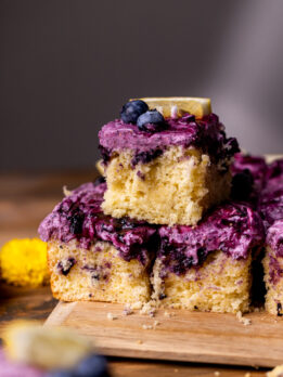 Three lemon blueberry cake slices stacked on top of each other.