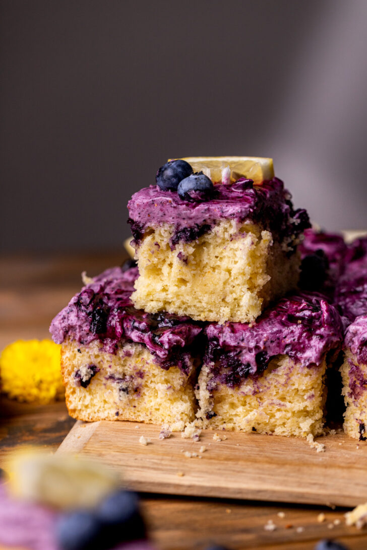 Three lemon blueberry cake slices stacked on top of each other.