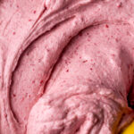 Raspberry frosting in a bowl.