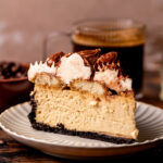One slice of tiramisu cheesecake on a plate.