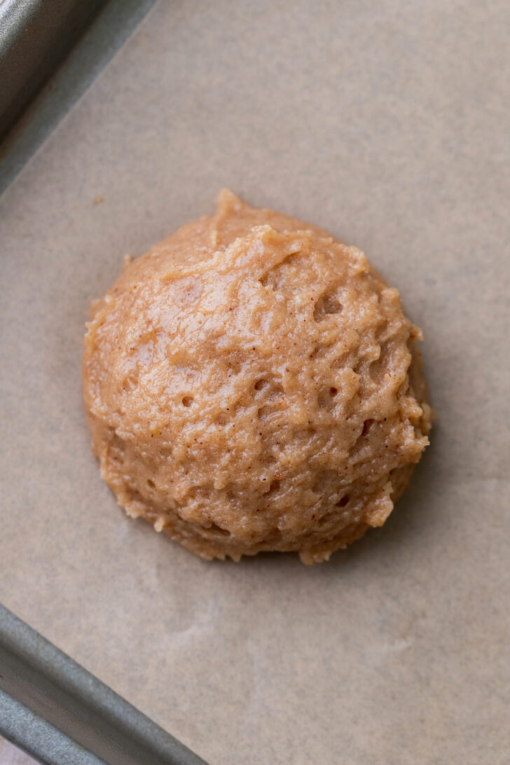 Cookie dough ball on a cookie sheet.