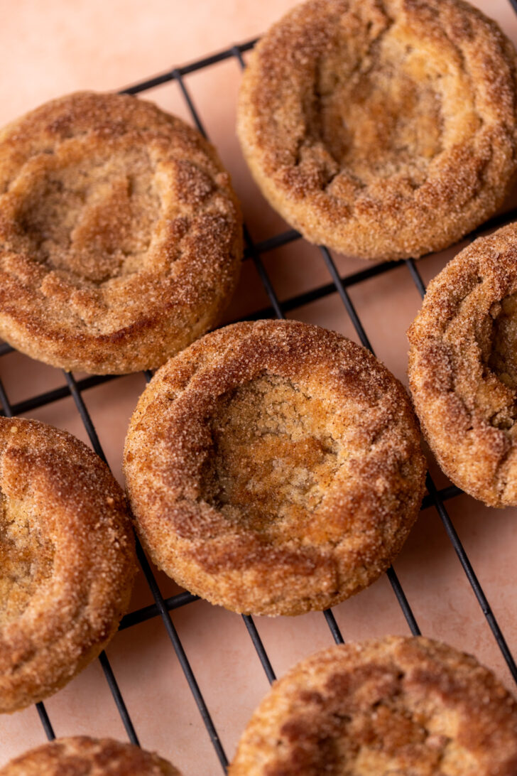 Cookies topped with cinnamon sugar on a wire rack.