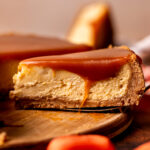 Slice of caramel cheesecake on the wood board.