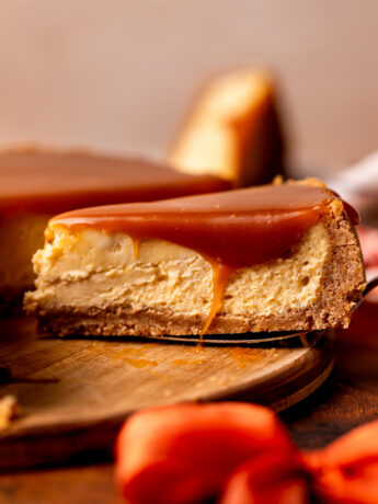 Slice of caramel cheesecake on the wood board.