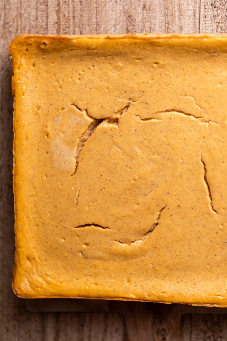 Baked cheesecake on a wood platter.