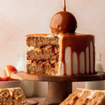 Split open caramel apple cake on a cake stand.
