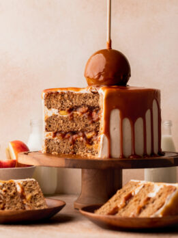 Split open caramel apple cake on a cake stand.