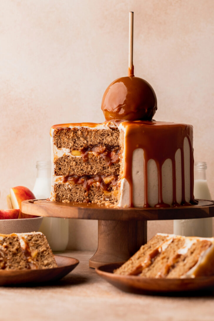 Split open caramel apple cake on a cake stand.