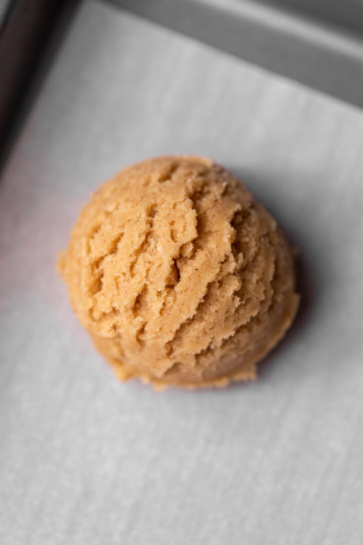 Cookie dough ball on a cookie sheet.