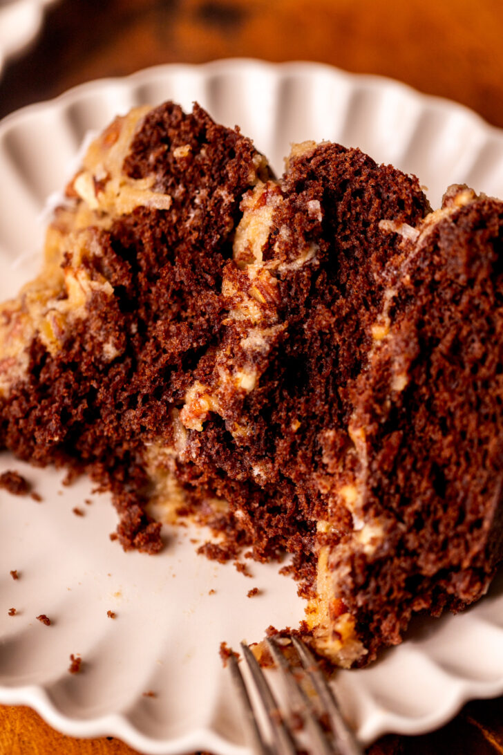 Bite missing from a slice of cake on a plate.